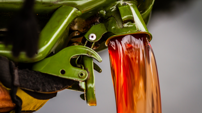 Red,Diesel,Being,Poured,Into,A,Container,In,A,Steady
