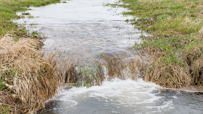 Motion,Blur,Of,Water,Flowing,In,Farm,Field,Waterway,To