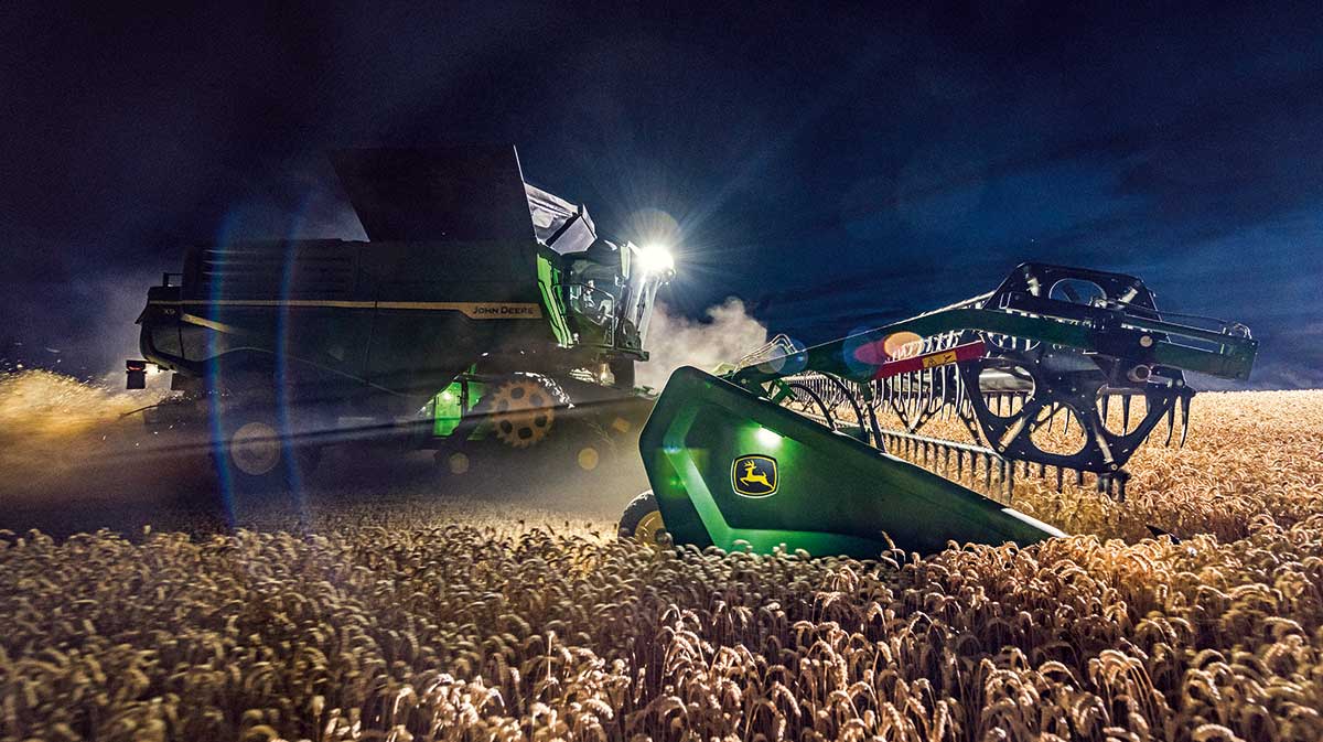 John Deere combine working at night