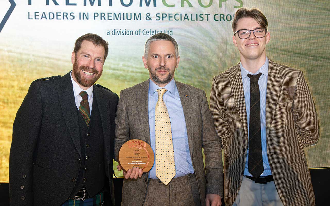 Richard Budd (middle) received the Oilseed Grower of the Year award from Matthew Lewis fromPremium Crops (right) and awards host Jim Smith